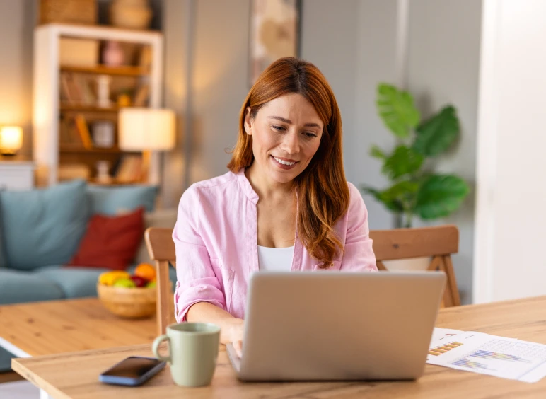 Relaxed woman on laptop with coffee nearby