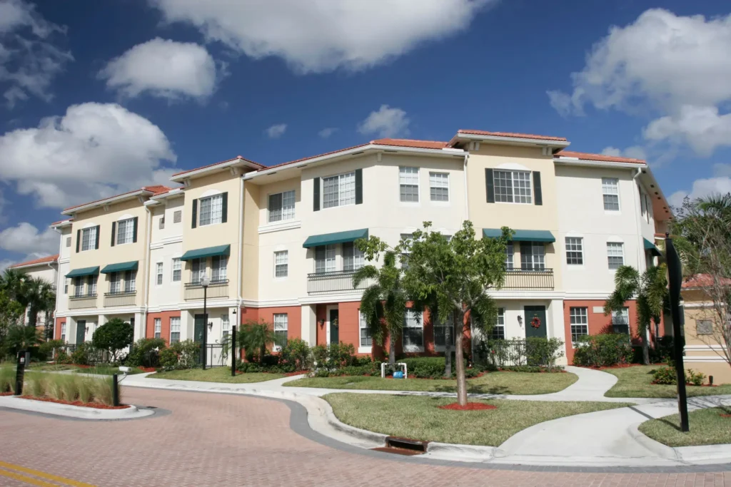 Apartment complex with trees and blue sky.