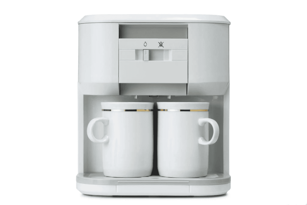Coffee maker with two white mugs.
