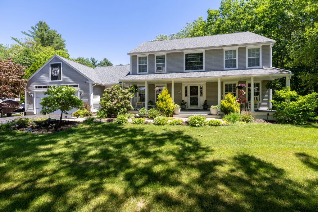 Two-story house with front porch and lawn.