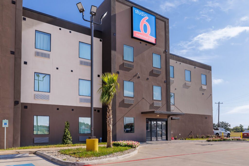 Modern hotel building with large sign.