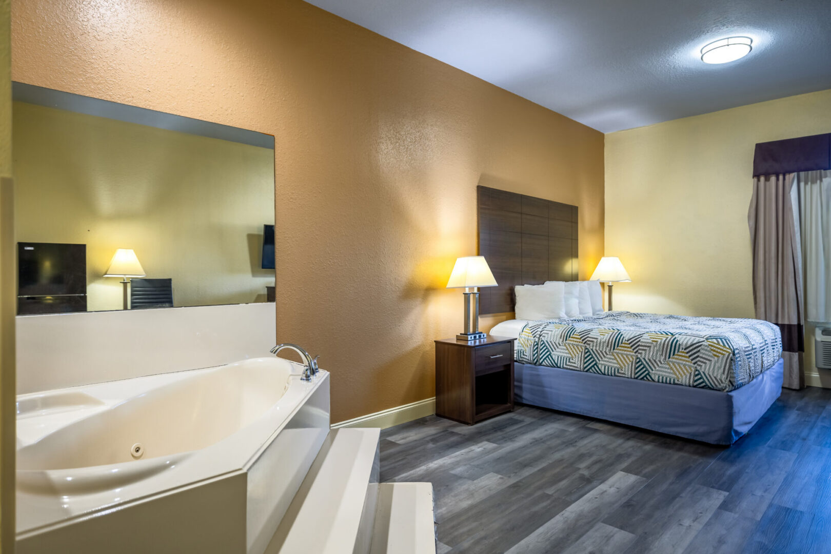 Hotel room with bed and jacuzzi.
