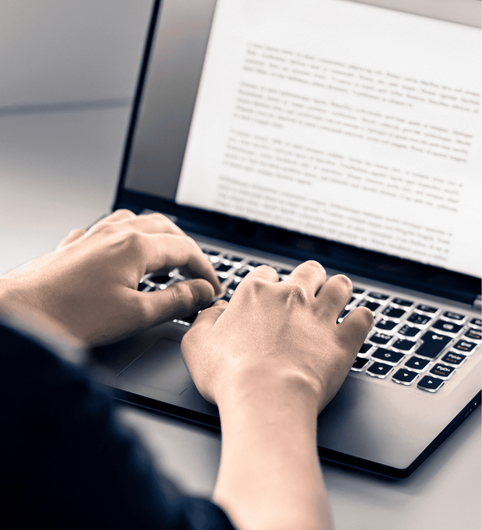 Hands typing on a laptop keyboard.