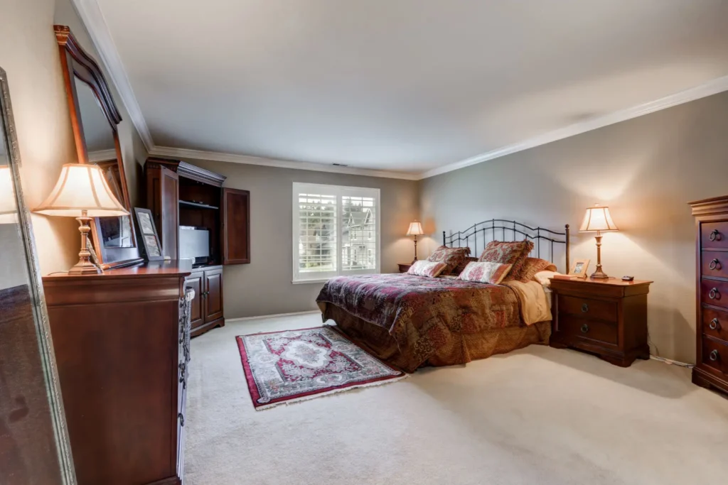 Elegant bedroom with large bed and lamps.