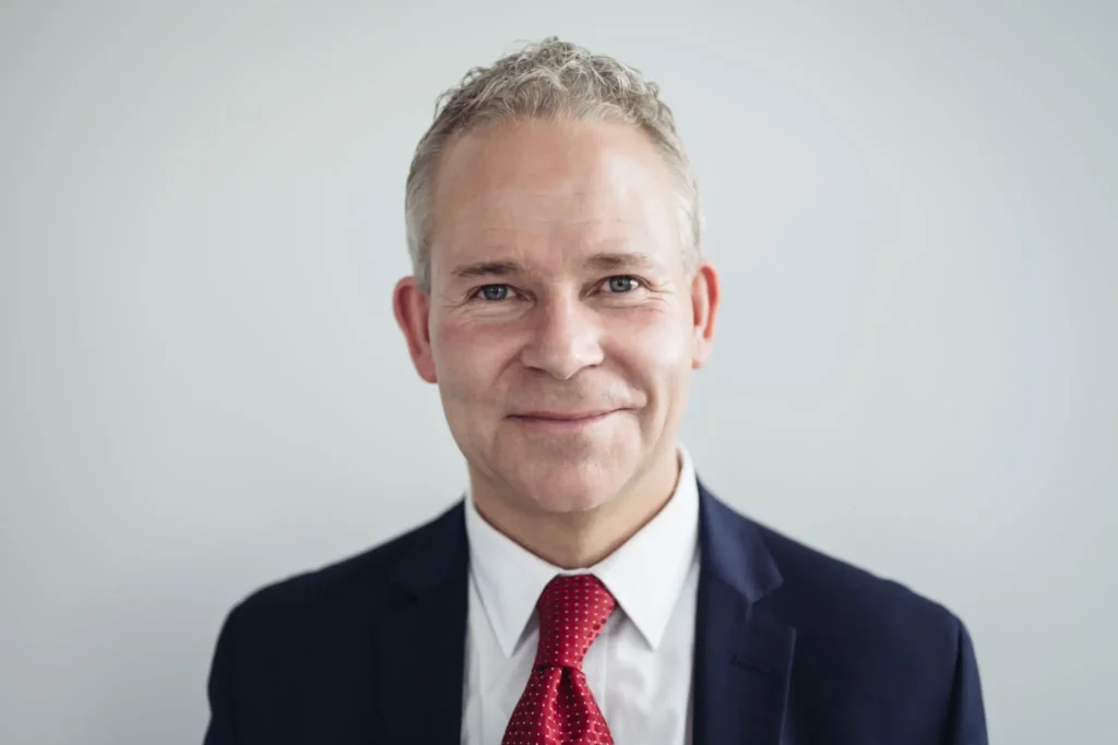 Smiling businessman in suit and red tie